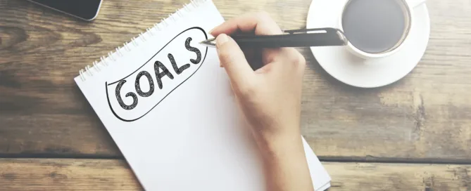 A person is writing a list of goals they want to achieve